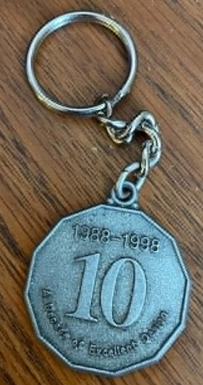 Silver keychain commemorating the 1988 to 1998 decade of excellence